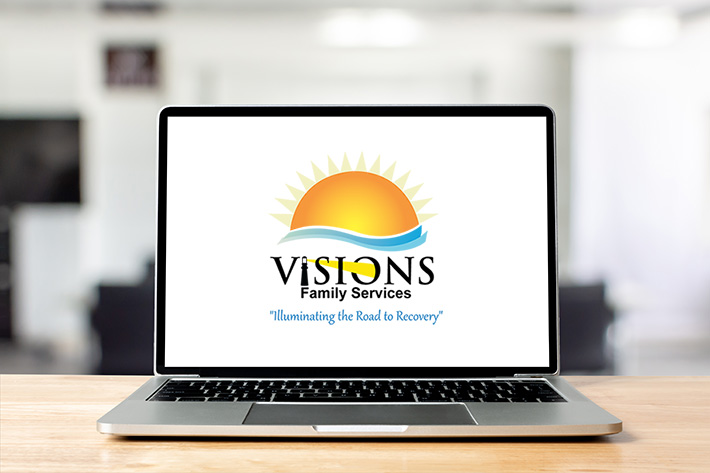 Laptop with Visions Family Services Logo